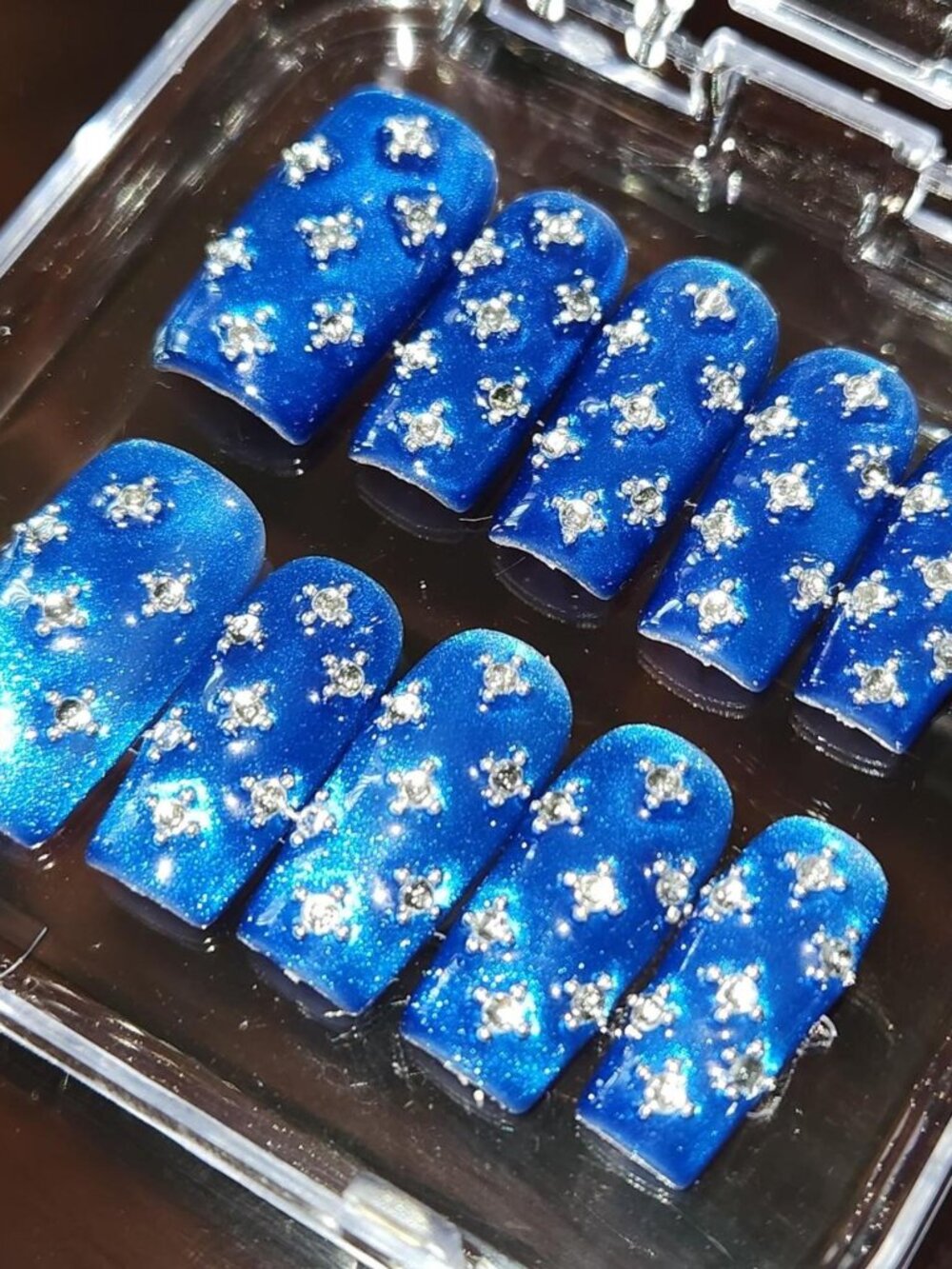 2.5 square blue cateye press-on nails with rhinestone embellishments.